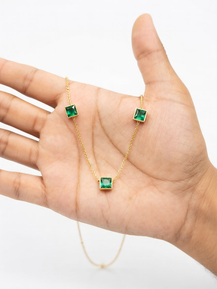 Silver plated emerald necklace from Ashir Studio featuring three vibrant green gemstones and intricate jewelry design.