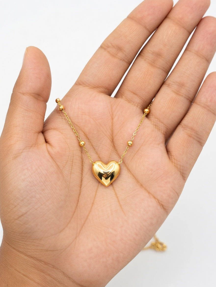 Gold heart-shaped necklace from Ashir Studio, elegant jewelry piece with a delicate chain and heart pendant.