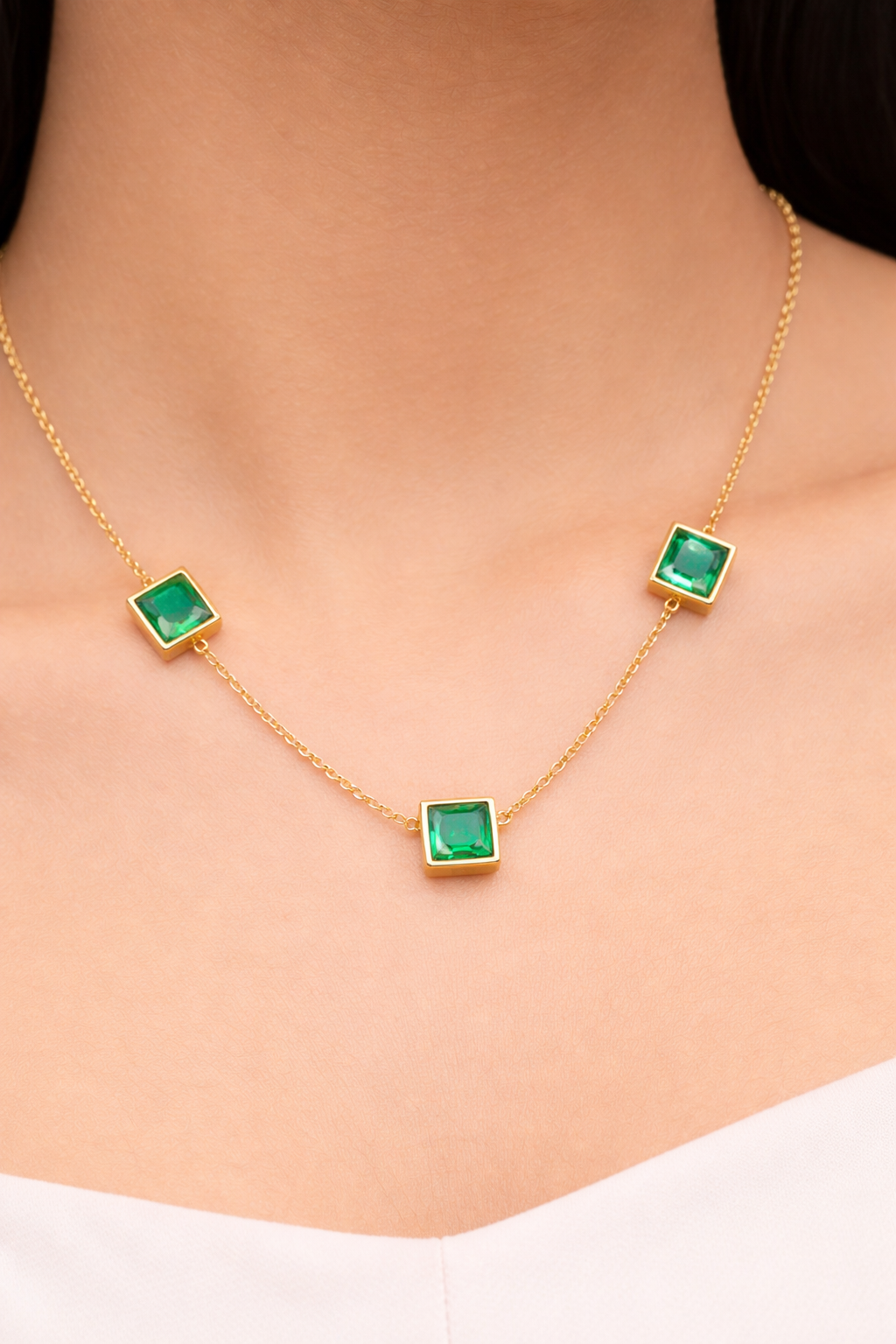 Elegant green emerald necklace featuring a plated gold chain from Ashir Studio, showcasing intricate jewelry craftsmanship.