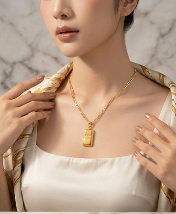 Gold bar pendant and Figaro chain necklace by Ashir Studio, featuring a sleek gold jewelry design on a white background.