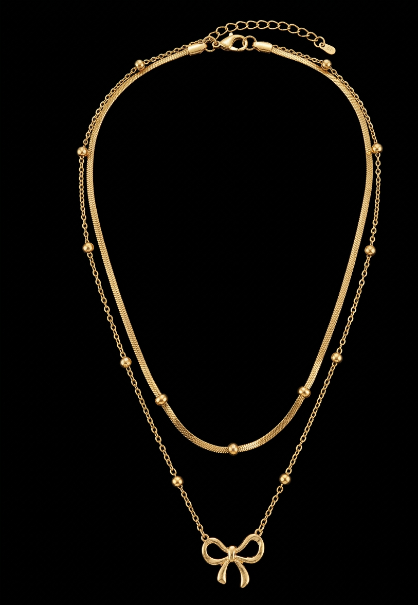 Gold bow necklace with double chain, elegant jewelry piece by Ashir Studio, featuring a delicate bow pendant on layered chains.