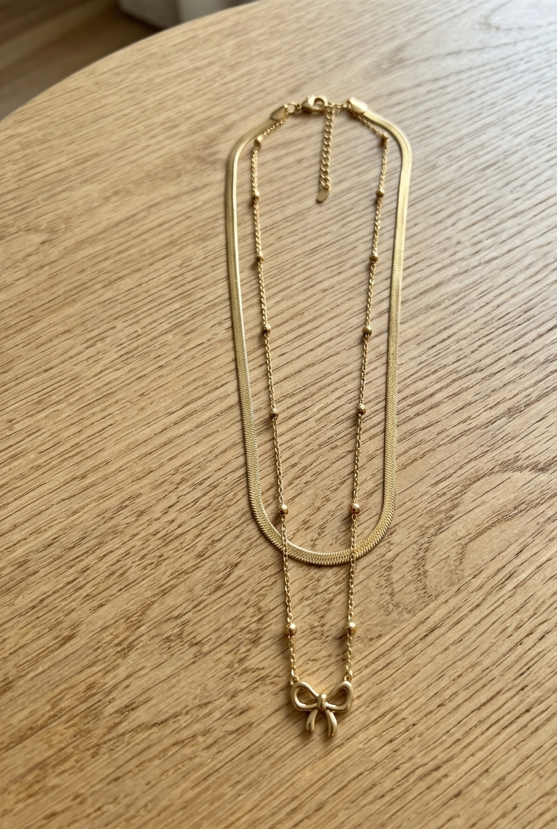 Silver bow necklace with double chain from Ashir Studio, featuring a delicate jewelry design with a stylish, layered look.