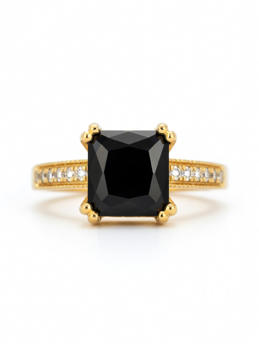 Emerald-cut black diamond halo ring in 18K yellow gold, showcasing elegant jewelry design with sparkling accents.